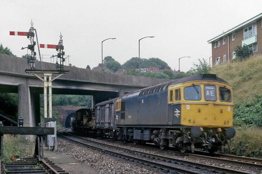 33024, down PW train, west of Salisbury tunnel 
 In these pre-internet days, the identification of trains such as this was all but impossible unless inside information was available! An unidentified PW train trundles down having just exited Salisbury tunnel led by 33024. With an AE identifier being carried I am sure that somebody out there may be able to enlighten me as to what this train may have been. It appears to be a short track-laying train with some track panels at the rear and a former Southern van directly marshalled behind the locomotive. 
 Keywords: 33024 down PW train west of Salisbury tunnel Permanent way infrastructure