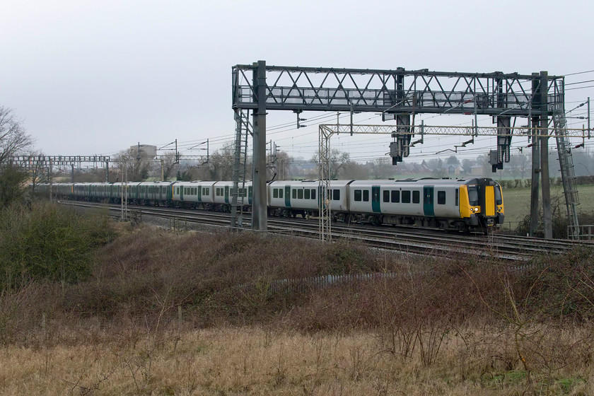 350124, 350101 & 350126, LN 12.05 Northampton-London Euston (2N06, 1E), Roade Hill 
 In the gloom of the last day of the year, the 12.05 Northampton to Euston Desiro service passes Roade Hill with the village of the same name in the background. The train is made up of three units all from the initial batch of thirty Desiros introduced between 2004 and 2005 by the then operator Silverlink. The Desiros never actually carried any Silverlink branding remaining in a livery very similar to the one being carried by 350124 in this photograph. Only when London Midland took over the franchise in late 2007 did the units receive a livery and branding matching their operator. 
 Keywords: 350124 350101 350126 12.05 Northampton-London Euston 2N06 Roade Hill London Northwestern Desiro