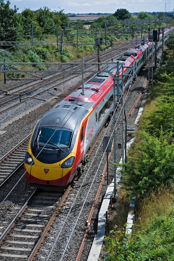 Class 390, VT 12.28 London Euston-Glasgow Central, Victoria bridge 
 At full line speed, an unidentified Virgin Class 390 passes Victoria bridge between Roade and Ashton working the 12.28 Euston to Glasgow Central service. The Pendolino will be slowing down slightly at this point as it enters the more winding section of its route between Roade cutting and Hilmorton Junction. 
 Keywords: Class 390 12.28 London Euston-Glasgow Central Victoria bridge Virgin Pendolino