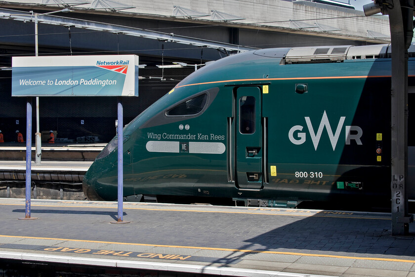 800310, GW 13.18 London Paddington-Cardiff Central (1B16, 1L), London Paddington station 
 At the country end of a sunbathed (and very hot) Paddington station 800210 'Wing Commander Ken Rees' waits to depart with the 13.18 GWR service to Cardiff Central. The IET was named in May 2021 at Swansea station in a ceremony that commemorated the life of the former World Warr II bomber pilot who died in 2014 at the ripe old age of ninety-three. After capture following being shot down in Norway WC Rees was imprisoned in Poland's Stalag Luft III where he made a number of escape attempts. It is alleged that Steve McQueens character in the 1963 film The Great Escape is said to be based on Ken due to his antagonistic attitude towards his captors and his persistent attempts to escape and not leas, his love of riding motorbikes! 
 Keywords: 800310 13.18 London Paddington-Cardiff Central 1B16 London Paddington station GWR IET Wing Commander Ken Rees