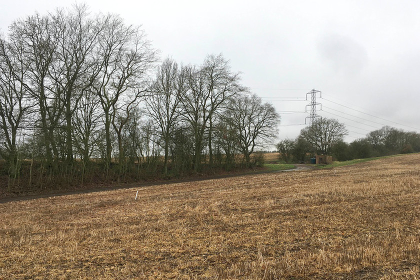 Former SMJR embankment & hut, Easton Neston SP712505 
 The route of the former SMJR can be seen on the embankment running from the left of the image towards the pylon. Although now obscured by trees, the distinctive shape of the embankment is clear to see. Where the farm track crosses the former trackbed a platelayer's hut still stands even if it is now roofless. This particular location is in the grounds of Easton Neston Park near to the estate village of Hulcote. 
 Keywords: Former SMJR embankment hut Easton Neston SP712505 Stratford-upon-Avon and Midland Junction Railway