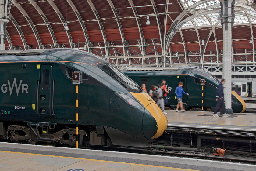 802001, GW 13.50 London Paddington-Great Malvern (1W21, RT) & 800303, GW 08.15 Penzance-London Paddington (1A80, 3L), London Paddington station 
 I took a photograph very similar to this back in 2005 on our return to London following a smashing weekend in Devon. Back then, sixteen years ago, the platform ends were filled with HSTs and a lone Class 332, just a few years old then. When I eventually get round to uploading this image it will be hyperlinked here by way of comparison...don't hold your breath though! In this 2021 scene, 802001 is nearest the camera that will soon work the 13.50 to Great Malvern whilst 800303's passengers are making their way along the platform having arrived on the 1A80 08.15 ex Penzance. 
 Keywords: 802001 13.50 London Paddington-Great Malvern 1W21 800303 08.15 Penzance-London Paddington 1A80 London Paddington station GWR Great Western Railway IET