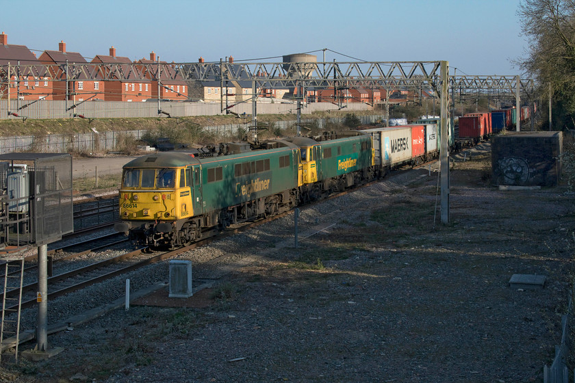 86614 & 86604, 11.13 Felixstowe North-Trafford Park (4M87, 24E), site of Roade station 
 Freightliner's 86614 and 86604 lead the 11.13 Felixstowe North to Trafford Park service past the site of Roade station taken from the footbridge that spans the lines. As has become a more common practice this week with the implementation of the much-reduced emergency timetable, control routed this on the down fast thus avoiding Northampton. The fourteen remaining Freightliner Class 86s are limited to seventy-five miles per hour so the driver of this service would need to keep the power on as a Pendolino was close behind! 
 Keywords: 86614 86604 11.13 Felixstowe North-Trafford Park 4M87 site of Roade station Cans Freightliner