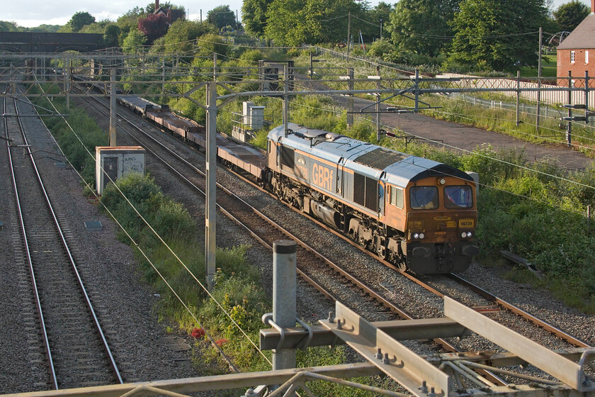 66729, 15.06 Garston Car Terminal-Dagenham Docks (6L48, 3E), site of Roade station 
 The empty Ford car train returns after delivery of a train of new vehicles to their Liverpool finishing and distribution centre. 66729 'Derby County' leads the 15.06 Garston to Dagenham Docks 6L48 through Roade. This is a very noisy train due to the unweighted nature of the wagons and is recognisable when heard passing through the village. It's nice to be taking pictures on a summer's evening in the sunshine, something that I have not managed so far this spring and summer! 
 Keywords: Derby 66729 15.06 Garston Car Terminal-Dagenham Docks 6L48 site of Roade station