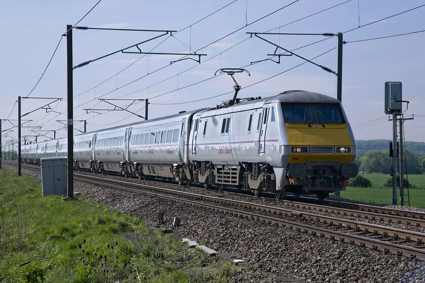 91104, GR 08.35 London King's Cross-Leeds (1D06), Frinkley Lane crossing SK906436 
 Frinkley Lane was utterly quiet and peaceful on this early on this spring morning that made waiting for trains to pass a very pleasurable experience, especially when compared to other occasions when we pursue our hobby in very different conditions! I whiled away the time between trains watching a blue tit that had chosen a nesting spot down inside the pole of a lineside warning sign frenetically feeding its brood. 91014 does its best to destroy this bucolic atmosphere as it passes leading the 08.35 King's Cross to Leeds service. 
 Keywords: 91104 08.35 London King's Cross-Leeds 1D06 Frinkley Lane crossing SK906436 East Coast