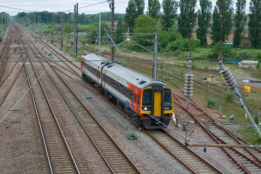 158862, EM 09.41 Nottingham-Norwich (1L06, RT), Tallington 
 From the lofty heights of Tallington's concrete and rather utilitarian footbridge EMR's 09.41 Nottingham to Norwich service is seen worked by 158862. This service was supposed to have originated from Liverpool Lime Street but this leg of its journey was cancelled, as was a later service, indicating that EMR has still yet to sort out these cross-country services that have been in a constant state of flux for some time now.; not good enough is it really? 
 Keywords: 158862 09.41 Nottingham-Norwich 1L06 Tallington EMR East Midlands Railway