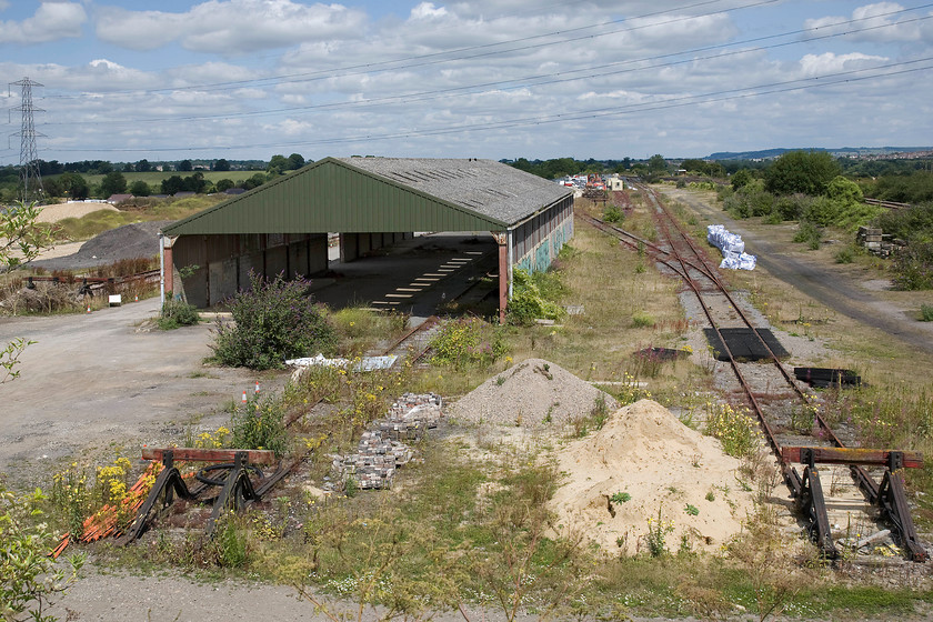 Former fertilizer distribution depot, Thingley Junction looking east 
 The fertilizer distribution depot to the northern side of Thingley Junction has been out of use for some years but the siding remain rail connected. The extensive empty space has been wisely kept by Network rail and is now to be the home of the contractors working to construct the massively delayed and over-budget GWML electrification. For a time in the 1990s the sidings were used to store redundant Mk. 1 stock and, on occasions, some locomotives that included 50017 'Royal Oak'. On one occasion towards the end of this period, I passed the junction on a train on a Sunday evening and witnessed a Mk. 1 coach fully ablaze with the fire engine in attendance. In this remote location, it will have been as a result of vandals I suspect. 
 Keywords: Former fertilizer distribution depot, Thingley Junction looking east