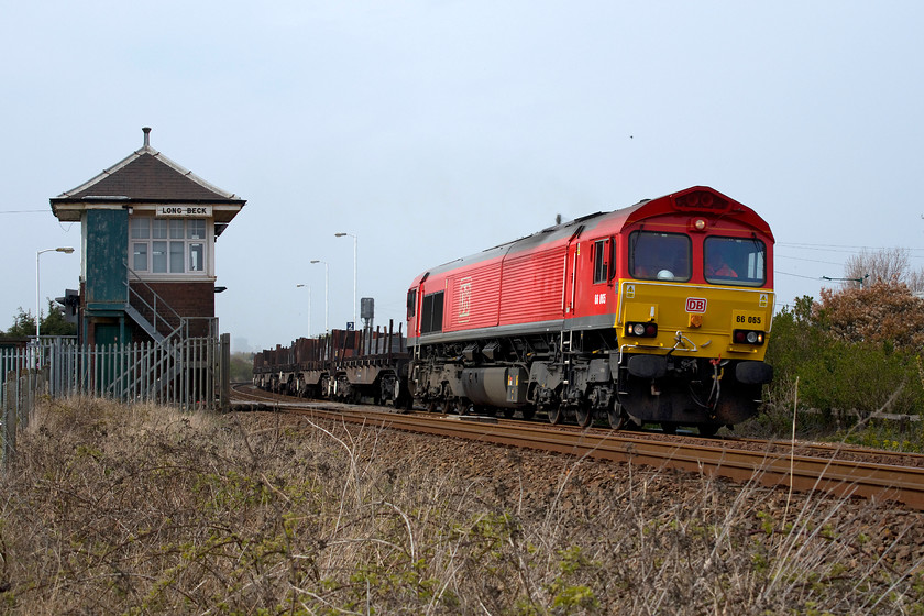 66065, 13.40 Tees Yard-Skinningrove BSC (6N40), Long Beck level crossing 
 A striking picture of 66065 as it passes Long Beck signal box and level crossing that is on the line to Saltburn. The DB class 66 is hauling the 13.40 Tees Yard to Skinningrove BSC train of loaded slab steel. It's surprising that on the national timetable, this working still is shown as going to Skinningrove BSC as this publicly owned company has not existed since 1988 when Thatcher and her divisive administration privatised it forming British Steel, later to become owned by Corus and now Tata. The train is seen passing the superb LNER Long Beck signal box. 
 Keywords: 66065 13.40 Tees Yard-Skinningrove BSC 6N40 Long Beck level crossing