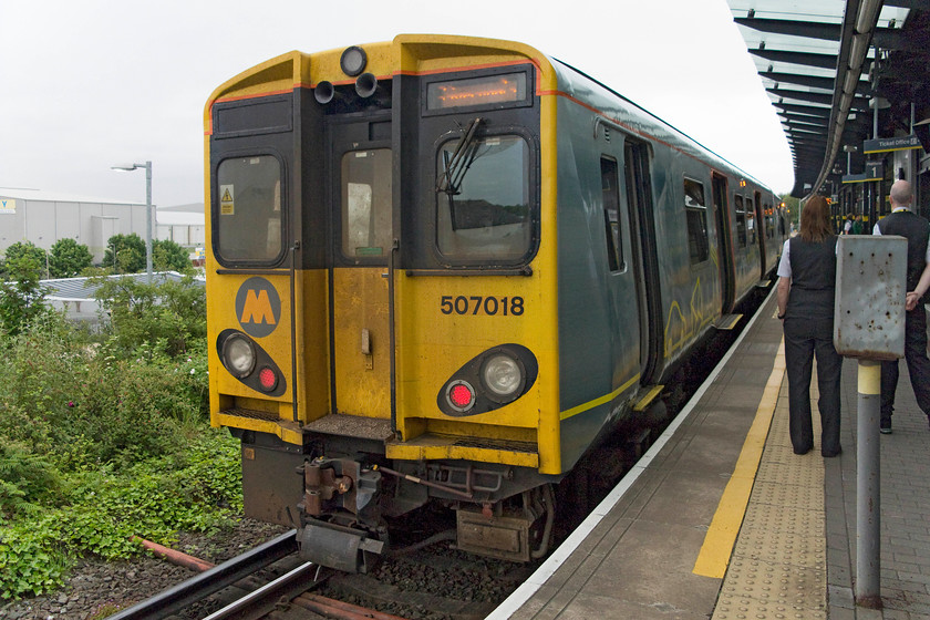 507018, ME 09.05 Ormskirk-Liverpool Central (2G30, 2L), Sandhills station 
 The elevated station at Sandhills serves the commercial district located in the old dockland area to the north of Liverpool city centre. It was a pretty bleak station up to when it was virtually re-bulit from the bottom up opening again in 2008. 507018 waits to depart with the 09.05 Ormskirk to Liverpool Central. 
 Keywords: 507018 2G30 Sandhills station