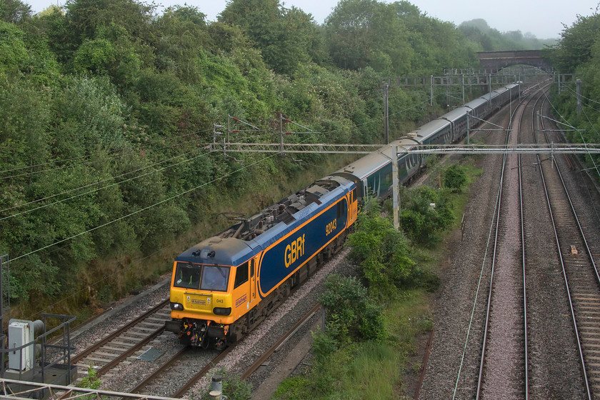 90043, CS 23.40 Glasgow Central & 23.40 Edinburgh Waverley-London Euston (1M11, 37L), A508 bridge 
 Once again running very late and in short formation, the up Lowland sleeper passes Roade's A508 road bridge. 90043 leads the train that has no Glasgow portion due to logistical problems relating to a shortage of the new Mk. IV CAF stock. It seems that all new stock and trains seem beset with problems when introduced but the issues that CS are experiencing with the Mk. IVs seem extreme. Most of the problem seem associated with the old favourite 'software glitches'. The most serious resulted in a computer generated emergency brake application of an up service that resulted in every bogie having to go for turning due to them all having severe flats. I suspect that the passengers asleep in their berths were a little nonplussed at being thrown about when this happened! 
 Keywords: 90043 23.40 Glasgow Central 23.40 Edinburgh Waverley-London Euston 1M11 A508 bridge