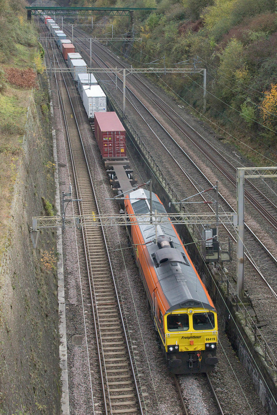 66419, 09.46 Felixstowe North-Crewe Basford Hall (4M87), Roade cutting 
 Looking smart in its Freightliner Genesee and Wyoming livery 66419 leads the 4M87 09.46 Felixstowe to Crewe through Roade cutting. At this point in the cutting, the train is just dropping away and below from the fast lines as it is about to curve off to its right to take the Northampton route to re-join the fast lines again at Hilmorton Junction just south of Rugby. 
 Keywords: 66419 09.46 Felixstowe North-Crewe Basford Hall 4M87 Roade cutting