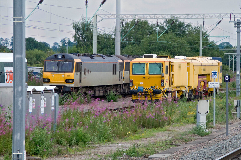 92044, 92043 & tamper, stabled, Rugby station 
 Consecutively numbered 92044 'Couperin' and 92043 'Debussy' sit stabled at Rugby in the sidings to the north of the station. In addition, is a rather faded tamper machine and a former FGW NVA Motorail wagon now branded with the TNT logistics company's logo. This was used as part of a short-lived experiment to deliver nighttime food freight into Euston. 
 Keywords: 92044 92043 tamper Rugby station