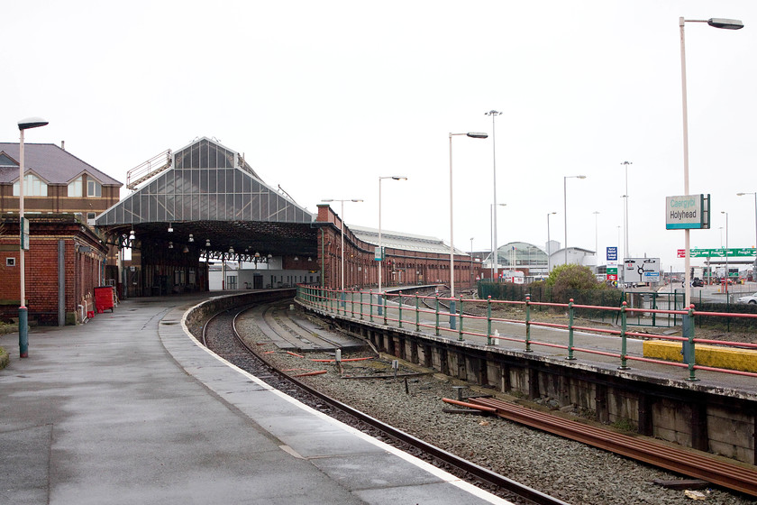 Holyhead station 
 A familiar site to many a traveller intending to sail to Ireland is Holyhead station. With the ferry terminal in the distance, the station is seen with its curved platforms. It is not as busy as it once was with some platforms taken out of use. The adjacent Freightliner terminal also shut in the 1990s that quietened things down either further. The vacated land was used to expand the car parking facilities. 
 Keywords: Holyhead station