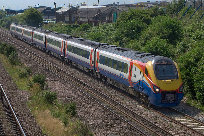 222003, EM 09.58 London St. Pancras-Sheffield (1F21), Finedon Road industrial estate SP900702 
 222003 'Tornado' leaves Wellingborough working the 09.58 St. Pancras to Sheffield 1F21 service. Notice this Meridian's small vinyl 'nameplate' located between the driver's door and the first passenger door of the train. It was turning into a very hot day and with me fully dressed in my work 'uniform' consisting of a suit and tie I was struggling to find a shady spot to stand in between trains! 
 Keywords: 222003 09.58 London St. Pancras-Sheffield 1F21 Finedon Road industrial estate SP900702 Tornado East Midlands Trains Tornado