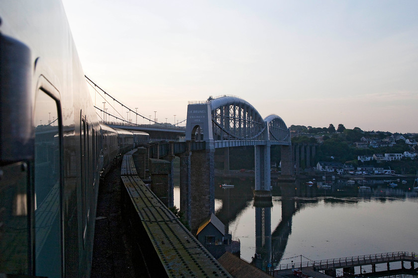 23.45 London Paddington-Penzance Sleeper (1C99, 2E), Royal Albert Bridge 
 After crossing the Royal Albert Bridge I turned the camera back towards Devon. I love the lighting in this particular shot. The absolutely still water of the River Tamar reflects Brunel's impressive 2000 foot long structure that was opened in 1859 really clearly. Some fifteen hours later Andy were back at Saltash station having visited all the Cornish stations bar two! I took a very similar image when I last crossed this amazing structure back in 2015 on an HST and tool a very similar photograph, see...... https://www.ontheupfast.com/p/21936chg/29042983604/x43133-10-06-london-paddington-penzance 
 Keywords: 23.45 London Paddington-Penzance Sleeper 1C99 Royal Albert Bridge