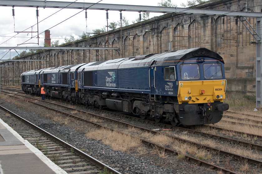 66304, 66301 & 66305, stabled, Carlisle station 
 Having brought the three Class 66s into Carlisle the driver has switched them off and is checking the locomotives before leaving them. I am not sure as to why 66304, 66301 'Kingmoor TMD' and 66305 were stabled here but I suspect that as the open day was still in full swing at DRSs Kingmoor depot than it was not possible to take them there as would normally be the case but it was certainly a treat for the spotters on the platforms! 
 Keywords: 66304 66301 66305 stabled, Carlisle station