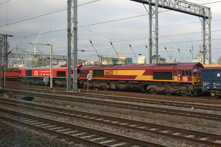 66136 & 66121, stabled, Wembley Yard 
 66121 and 66136 stand in Wembley yard at the head of a ballast train. There were none scheduled to leave or arrive on RTT so I could not identify what the working was. 66136 still looks very smart in its DB bright red livery complete with 'Yiwu-London Train' vinyls. The loco. was repainted and had the vinyls applied in January 2017 to commemorate the first 12 000 mile Freightliner service from Yiwu in China to Barking in London. 
 Keywords: 66136 66121 Wembley Yard