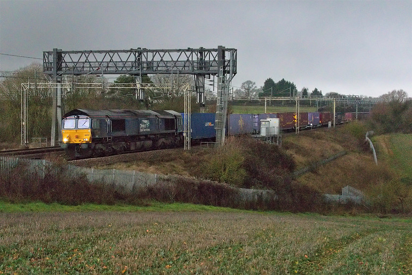 66302, 13.09 DIRFT-Ripple Lane (4L48), between Ashton & Roade 
 I really should have been making for home at this point as the rain was coming down and the light had all but gone! However, as I had made the effort to get out and that the Sunday 4L48 13.09 Daventry to Purfleet Freightliner was on its way I stuck it out! 66302 heads the train that, once again, was mysteriously terminated at Ripple Lane. It is seen here between Roade and Ashton on the southern WCML. 
 Keywords: 66302 13.09 DIRFT-Ripple Lane 4L48 between Ashton & Roade