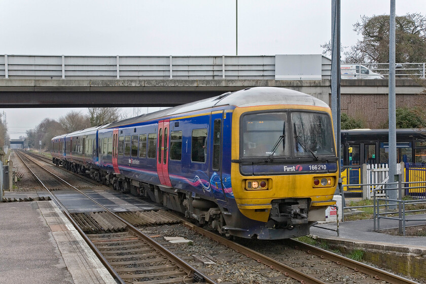 166210, GW 09.04 Reading-Redhill, North Camp station 
 The strange absence of a third rail on the eleven-mile section of the former London and South Western Railway route between Wokingham and Aldershot necessitates the use of diesel traction. First Great Western operate services on the line between Reading and Guildford with some services extended onwards as far as Gatwick Airport. 166210 arrives at North Camp station working the 09.04 Reading to Redhill service. North Camp station is located in Farnborough and is only a short walking distance from Ash Vale station which offers direct trains to Waterloo. 
 Keywords: 166210 09.04 Reading-Redhill North Camp station FGW First Great Western Turbo