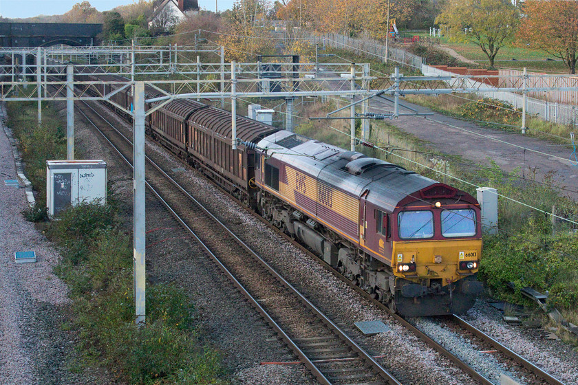 66013, 07.49 Ditton-Dollands Moor (6O16, 10E), site of Roade station 
 Despite running extremely late here passing Roade, the 07.49 Ditton Foundry Lane to Dollands Moor 6O16 actually arrived early due to its layover in Wembley Yard being cut very short. This is a new flow but I am unsure of what is actually being conveyed in its mix of Cargo Wagons and flats with plain boxes. Still wearing the EWS livery that it has had since its arrival in the UK during 1998 66013 leads the train. Thanks to Mike for identifying the headcode of this train. 
 Keywords: 66013 07.49 Ditton-Dollands Moor 6O16 site of Roade station EWS