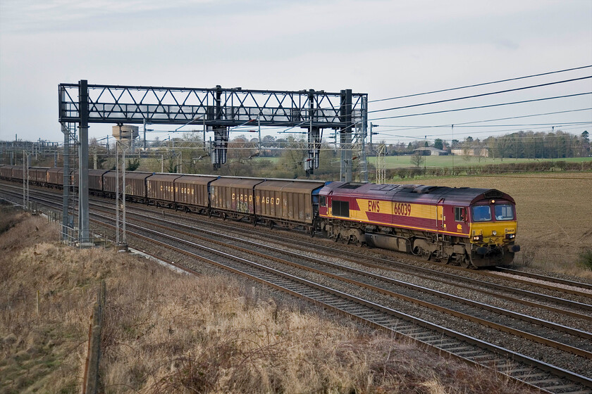 66039, DIRFT-Dollands Moor (6O67), Roade Hill 
 The daily empty bottled water train (6O67) passes southbound between Roade (in the background) and Ashton in Northamptonshire. Unfortunately, I have not framed the Daventry (DIRFT) to Dollands Moor particularly well is led by EWS' 66039 on this winter's afternoon. 
 Keywords: 66039 DIRFT-Dollands Moor Roade Hill 6O67