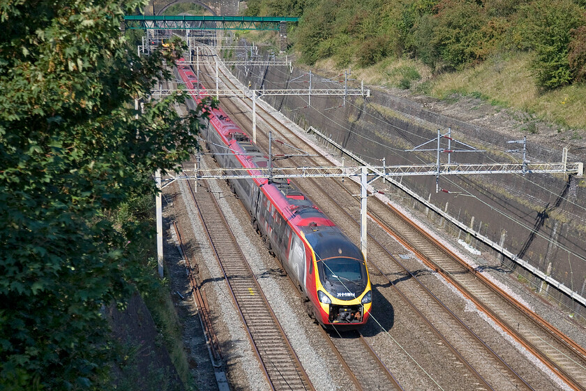 390155, VT 11.55 Manchester Piccadilly-London Euston (1A23), Roade cutting 
 390155 X-Men: Days of Future Past works the 1A23 11.55 Manchester Piccadilly to Euston Virgin service through Roade cutting. Another example of a Pendolino running with its draw gear cover in the retracted position that does nothing for its aerodynamic efficiency or its good looks! 
 Keywords: 390155 11.55 Manchester Piccadilly-London Euston 1A23 Roade cutting Virgin West Coast Pendolino X-Men: Days of Future Past