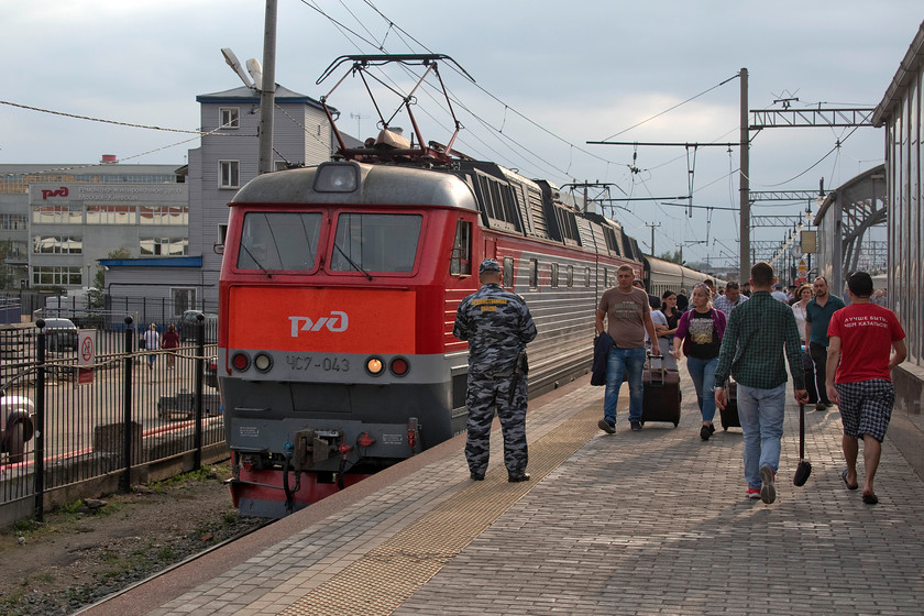 CHS7-043, 23.00 Chisinau-Moscow Kiyevsky (48), Moscow Kiyevsky-station 
 CHS7-043 has just arrived with the 23.00 from Chisinau. This train did not leave the previous night but a night previous to that taking over twenty-four hours to make the journey from the Moldovan capital! Due to Moldova's strategic location between Romania and Ukraine, police and security staff took a great deal of interest in its arrivals. Indeed, one is seen here watching carefully the people coming off the train with many being 'selected' and taken to one side for more detailed scrutiny. The Skoda built articulated CHS7 will be one of a number of locomotives that will have led the train that will have started its journey being diesel hauled as Moldova has no electrified track. 
 Keywords: CHS7-043 23.00 Chisinau-Moscow Kiyevsky 48 Moscow Kiyevsky station