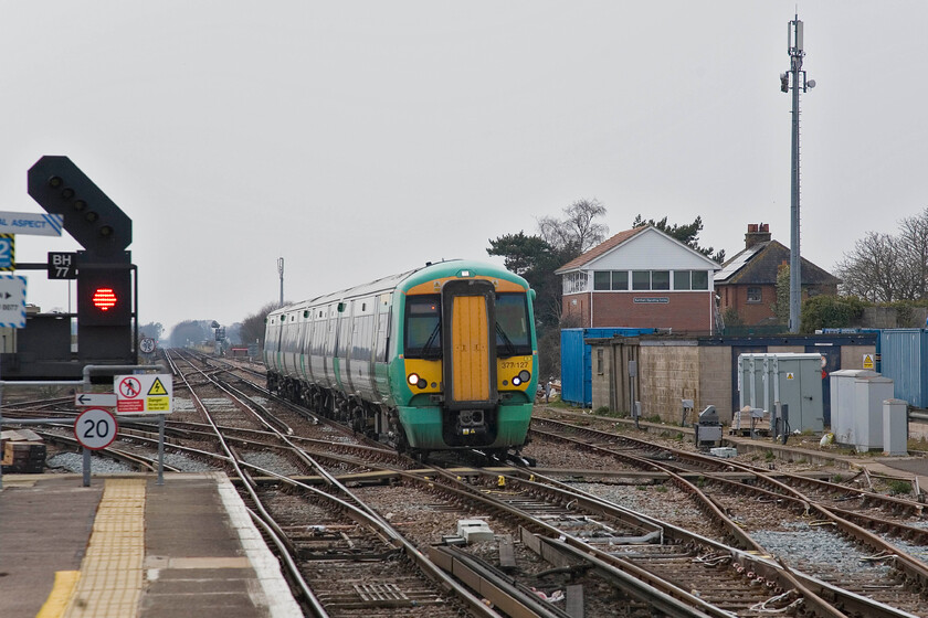 377127, SN 15.13 Southampton Central-London Victoria, Barnham station 
 The 15.13 Southampton Central to Victoria service arrives at Barnham station worked by 377127. It is about to pass over the pointwork that marks where the Bognor branch heads off to the south. I am standing very close to where the original 1911 London, Brighton and South Coast Railway (LBSCR) box was located until December 2009 to be replaced by the modern structure to the right of the train. 
 Keywords: 377127 15.13 Southampton Central-London Victoria Barnham station Southern Electrostar