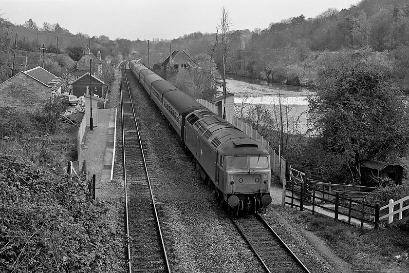 Class 47, unidentified down diverted working, Avoncliff station 
 An unidentified Class 47 heads along the Avon Valley towards Bathampton Junction just east of Bath where it will rejoin the GWML. The train is diverted along this route away from its normal line due to engineering works. It is passing through the diminutive halt at Avoncliff with the River Avon tumbling over a large weir in the background. Notice to the left a long-forgotten car of the era, a Peugeot 204 in estate form with its distinctive triangular rear light clusters. 
 Keywords: Class 47 down diverted working Avoncliff station