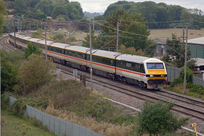 82139, LS 14.29 Crewe-London Euston (1Z40, 7L), Banbury Road bridge 
 Evoking an era dating back thirty years or so a perfect matching set of Intercity Swallow liveried stock, DVT and locomotive sweep along the West Coast Mainline operating what is ostensibly a service train. Locomotive Services Limited is operating what is actually classified as a charter but in reality, is a service train that anybody can join in order to get to London from Crewe and then back to Piccadilly again later in the early evening. This all comes in response to Avanti West Coasts' controversial temporary (but for how long?) decision to slash their return Manchester to Euston services. DVT 82139 leads the 1Z40 14.29 Crewe to Euston service past Banbury Lane crossing on the Weedon loop with 87002 'Royal Sovereign' providing the power at the rear. 
 Keywords: 82139 14.29 Crewe-London Euston 1Z40 Banbury Road bridge LSL Locomotive Services Limited DVT 87002 Royal Sovereign