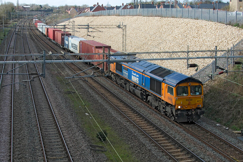 66731, 13.53 Birch Coppice-London Gateway (4L68, RT), Ashton Road bridge 
 Celebrity member of the class of many, 66731 Captain Tome Moore A True British Inspiration passes Ashton Road bridge leading the 13.53 Birch Coppice to London Gateway 4L68 intermodal working. Two years on from the dark days of the Coronavirus crisis when this locomotive was named it still looks very smart which is a testament to how GBRf maintain their fleet with them always being well turned out especially when compares to other operators. 
 Keywords: 66731 13.53 Birch Coppice-London Gateway 4L68 Ashton Road bridge GBRf Captain Tome Moore A True British Inspiration