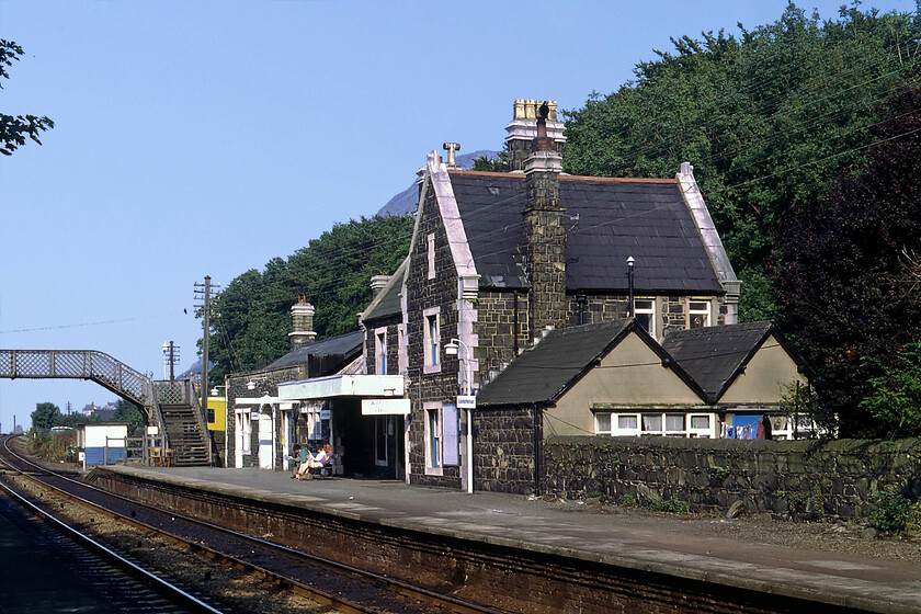 Llanfairfechan station 
 Llanfairfechan is situated on the North Wales coast between Bangor (west) and Conwy (east). As a relatively small settlement, it was blessed with a nice station that is seen here looking eastwards towards Penmaenmawr. There was once a charming L&NWR signal box located on this side of the track just beyond the footbridge that was demolished in 1971 following a period of use as a PW hut. Unfortunately, when the A55 North Wales Coast dual carriageway was constructed in the late 1980s the station building was demolished and the trees felled seen here to make for the new road. It runs directly behind the down platform with all that remains from this 1981 scene being the footbridge. 
 Keywords: Llanfairfechan station