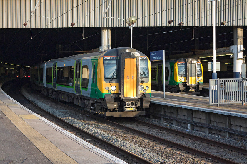 350122, LM 19.24 London Euston-Milton Keynes Central (2K13, RT) & 350239, LM 19.34 London Euston-Tring (2T15, RT), London Euston station 
 350122 and 350239 stand in the evening sun at London Euston station. Both are going to leave within ten minutes of each other, 122 is forming the 19.24 to Milton Keynes and 239 the 19.34 to Tring. 
 Keywords: 350122 2K13 350239 2T15 London Euston station