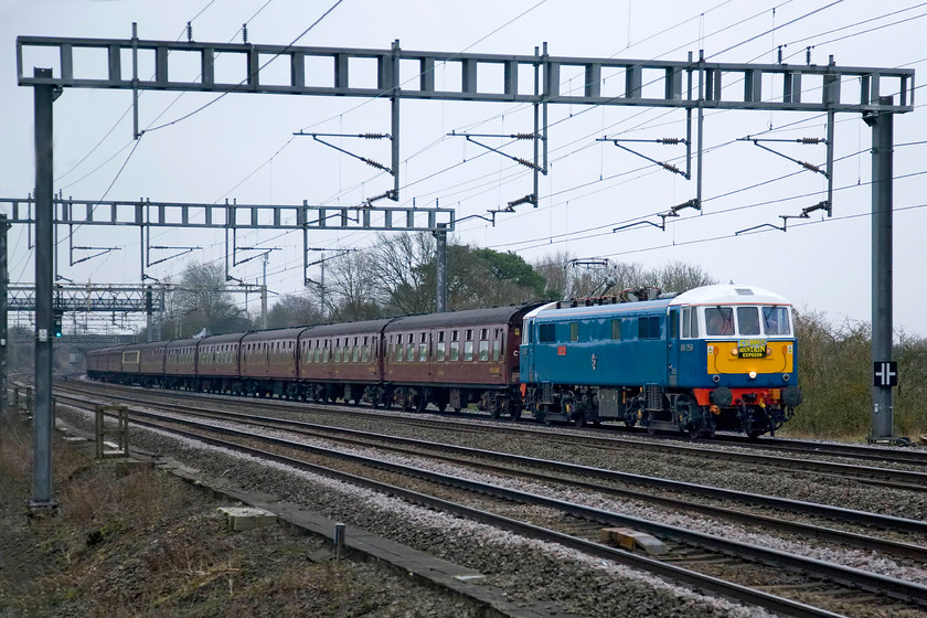 86259, outward leg of The Winter Cumbrian Mountain Express, 07.09 London Euston-Carlisle (1Z86), Ashton Road bridge 
 The electric blue of 86259 'Les Ross/Peter Pan' brightens up a drab scene in South Northamptonshire. The vintage AC electric is hauling yet another Saturday Winter Cumbrian Mountain Express (the sixth week in a row) running, as usual, as 1Z86 and leaving Euston at 07.09. The charter was hauled to Carnforth by the electric where 46115 'Scots Guardsman' would take over. 
 Keywords: 86259 The Winter Cumbrian Mountain Express 07.09 London Euston-Carlisle 1Z86 Ashton Road bridge AL6 West Coast Railways Les Ross Peter Pan