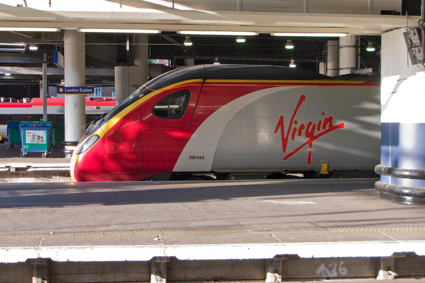 390042, VT 14.42 Glasgow Central-London Euston (1M15), London Euston station 
 A broadside view of 390042 following its recent arrival at Euston with the 14.42 from Glasgow Central. One cannot argue that the shape of the Pendolino, quite a pioneer in rail travel when introduced in 2002, is purposeful and quite elegant. Virgin, who has run them since new, are currently preparing their bid to maintain their hold on to the west coast services for another seven years; I wonder if they will be successful? 
 Keywords: 390042 14.42 Glasgow Central-London Euston 1M15 London Euston station Virgin Trains West Coast Pendolino