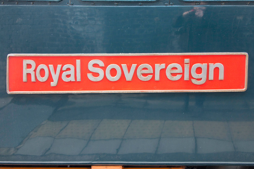 Nameplate, 87002, CS 08.27 London Euston-Wembley Sleeper ECS (5M11), London Euston station 
 The nameplate of 87002 'Royal Sovereign' taken at Euston station about five feet from the subject! I have had to indulge in some Photoshop manipulation in order to irradiate barrel and pincushion distortion; I have almost been successful! I like the Midnight Teal Caledonian Sleeper livery, it is akin to the BR blue of the 1970s. and gives a 'classy' look to the locomotives and stock. 
 Keywords: Nameplate 87002 CS 08.27 London Euston-Wembley Sleeper ECS 5M11 London Euston station