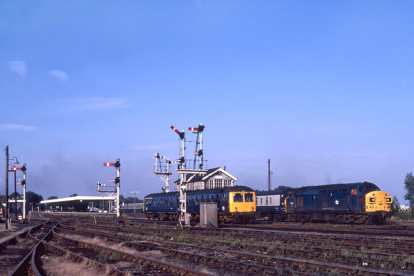 Class 105, 17.30 Ely-Cambridge & 37087, 16.42 Peterborough-Harwich Parkstone Quay (1C18), Ely South 
 As the 17.30 Ely to Cambridge Class 105 DMU service gets away from Ely station passing the South signalbox the 1C18 16.42 Peterborough to Harwich Parkston Quay also leaves worked by 37087. The latter will head off at Dock Junction on the single line via Soham onwards to Ipswich where the locomotive will either have been removed or worked through and returned as class37.co.uk has it working the 1K47 2145 Ipswich to Liverpool Street later in the evening. The DMU will simply make the short hop south on the main line to Cambridge. Notice that a down train is pegged for the submissive route to March, this train is seen in the next photograph of the sequence. 
 Keywords: Class 105 17.30 Ely-Cambridge 37087 16.42 Peterborough-Harwich Parkstone Quay 1C18 Ely South First generation dmu