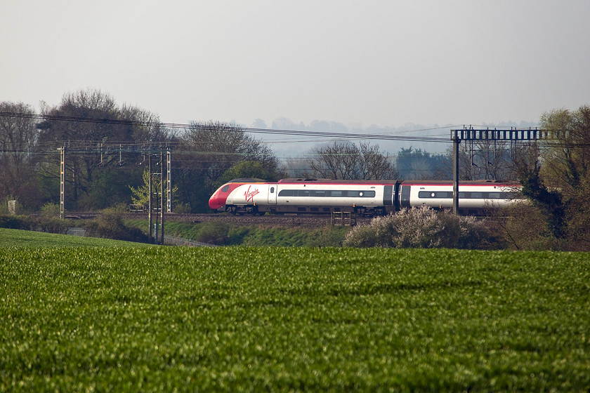 390127, VT 08.40 London Euston-Manchester Piccadilly (1H63, 2L), between Roade & Ashton 
 With this lighting, the state of the fields and the trees it can only be spring time! 390127 'Virgin Enterprise' brings up the rear of the 08.40 London Euston to Manchester Piccadilly. It is seen passing through the spring countryside between Roade and Ashton in Northamptonshire. 
 Keywords: 390127 1H63 between Roade & Ashton