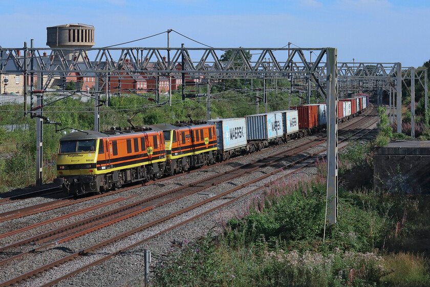 90048 & 90014, 11.13 Felixstowe North-Ditton (4M87, 6E), site of Roade station 
 It's always nice to see a matching pair of locomotives hauling any train but a pair of orange Freightliner liveried locomotives look particularly impressive. 90048 leads 90014 'Over The Rainbow' as they work the 4M87 11.13 Felixstowe to Ditton service past Roade. In common with most freight seen this week on my outings, this one was well loaded with just a few empty flast towards the rear of the train. This photograph is taken using the digital zoom on the Canon G1X, something that only really works successfully in weather and lighting conditions such as this where a very low ISO (400) and small aperture (f5.6) are possible. 
 Keywords: 90048 90014 11.13 Felixstowe North-Ditton 4M87 site of Roade station Freightliner 	Over The Rainbow