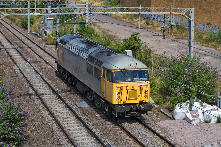 56311, 11.10 Washwood Heath-Wembley Yard (0Z56), site of Roade station 
 Formally numbered 56057 but now running as 56311 passes light engine through Roade on a warm summer's lunchtime. British American Railway Services (BARS) operates this locomotive under their Devon & Cornwall Railways (DCR) brand. It is working the 0Z56 11.10 Washwood Heath to Wembley Yard probably heading to London to operate one of Colas' various contracts in the London area. 
 Keywords: 56311 11.10 Washwood Heath-Wembley Yard 0Z56 site of Roade station Devon and Cornwall Railway DCR British American Railway Services BARS