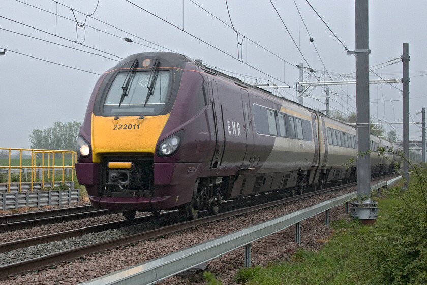 222011, EM 09.31 London St. Pancras-Sheffield (1F17, RT), Wymington SP946644 
 222011 tears down from Sharnbrook summit with the 09.31 St. Pancras to Sheffield service. It is passing near to the Bedfordshire village of Wymington in the pouring rain. This photograph took a little bit of work in Photoshop to bring it round with particular work needing to be aimed at the darker areas and the purple livery of the unit. 
 Keywords: 222011 09.31 London St. Pancras-Sheffield 1F17 Wymington SP946644 EMR East Midlands Railway Meridian