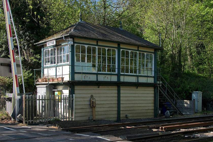 Ketton signal box (Mid, 1900) 
 I have a number of photographs of Ketton signal box over the years and very little has changed since the first one was taken in 1981. The 1900 Midland structure still retains many of its original features from its windows, the finials and the balcony now in use to hold plant pots! Unfortunately, the wooden steps have been replaced by a horrible galvanized carbuncle and the gates superseded by barriers way back in 1974. The box and associated semaphores are scheduled for replacement very soon. 
 Keywords: Ketton signal box