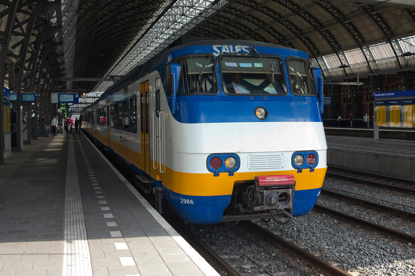 2986, 14.52 Rhenen-Uitgeest (NS 7450), Amsterdam Central station 
 These class SGMs are referred to as Sprinters. Whilst they bear no resemblance to the UK trains of the same name their function is similar. They were introduced in the mid-1970s but were heavily refurbished in the early 2000s by NedRail so are still in frontline service. This working is a cross-Amsterdam service, the 14.52 from Rhenen to Uitgeest. Rhenen is a small town that saw a lot of World War 2 action where the Dutch army tried valiantly to resist the German invasion in 1940, also, it is on relatively high land being a lofty 140ft above sea level! 
 Keywords: 2986 14.52 Rhenen-Uitgeest NS 7450 Amsterdam Central station