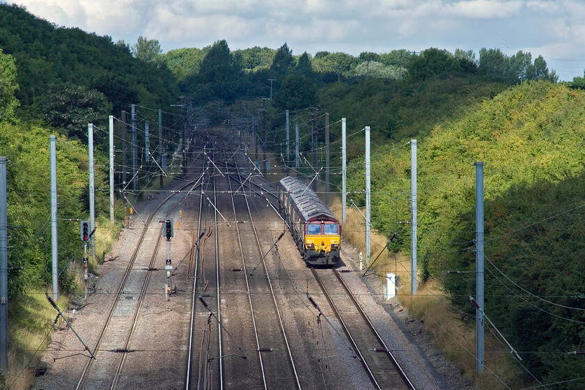 66184 & Class 66, 06.48 Immingham Maintenance Shed-Whitemore Yard (0X14), Westby SK962271 
 Six Class 66s head for maintenance and servicing past Westby in Lincolnshire. They have just emerged from Stoke tunnel and joined the up slow line to continue their journey the relatively short distance to Peterborough and then east to March's Whitemoor Yard. Running as 0X14 the line-up left Immingham at just before 07.00 and is led by 66184 with none of the others, unfortunately, identifiable. 
 Keywords: 66184 Class 66 06.48 Immingham Maintenance Shed-Whitemore Yard 0X14 Westby SK962271 EWS Light engine