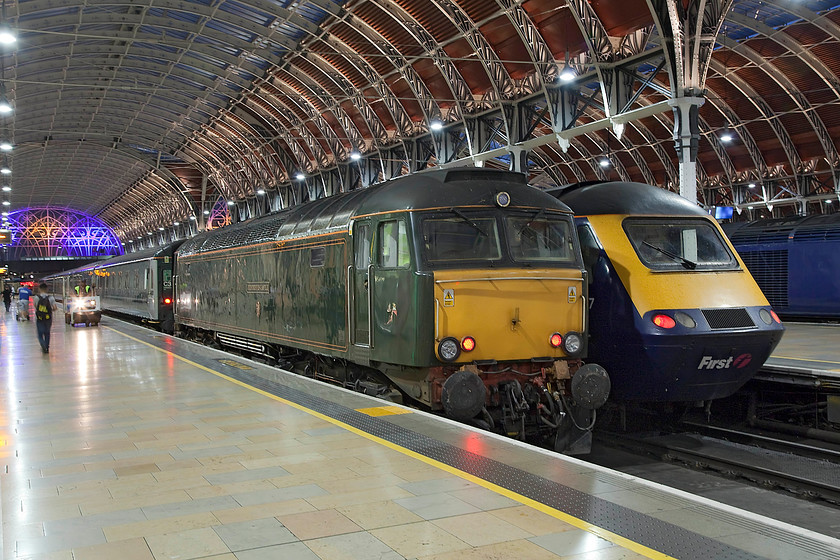 57604, 21.20 Old Oak Common-London Paddington Sleeper ECS (5C99) & class 43, GW 22.45 London Paddington-Swansea (1B94, 1E), London Paddington station 
 The magnificent elegance of Brunel's train shed at Paddington takes on a whole new look at night with the modern lighting that illuminates it huge cast iron spans. Standing, as it does every night, at platform one is the Night Rivera Sleeper stock that has just arrived from Old Oak Common depot. It runs into Paddington as 5C99 arriving an hour or so before schedule departure time. On this night, 57604 'Pendennis Castle' did the honours with an unidentified HST next to it about to leave with the 22.45 to Swansea. 
 Keywords: 57604 Sleeper ECS 5C99 class 43 1B94 London Paddington station