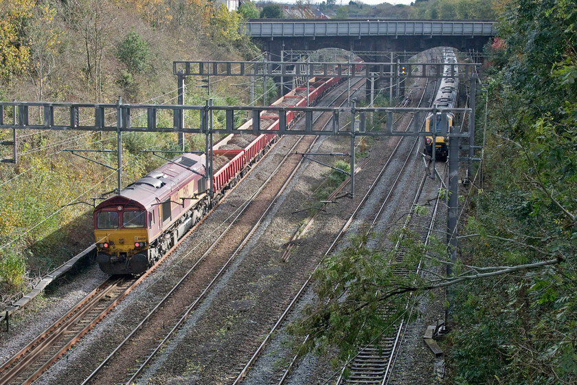 66059, Rugby-Bescot (6R01), Hyde Road bridge 
 66059 is dragged at the rear of the 6R01 Rugby to Bescot engineering train through Roade cutting past the stationary Voyager 221106. Visible to the right is the small ash tree that has been blown down on to the catenary neatly resting on the feed wire with the contact wire layin on the track below. The Voyager will soon creep back southwards to Milton Keynes wrong line unable to make it any further north with more trees on the catenary towards Blisworth and Weedon. 
 Keywords: 66059 Rugby-Bescot 6R01 Hyde Road bridge EWS DB