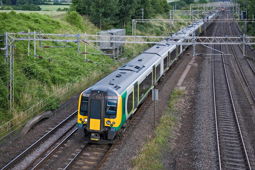 350239, LM 17.51 London Euston-Northampton, Victoria bridge 
 Despite the sun not being out it was, in fact, a warm summer's evening. 350239 leads two other Desiros working London Midland's 17.51 Euston to Northampton service. Being composed of three sets, twelve cars, is indicative that it is classified as a commuter working. 
 Keywords: 350239 17.51 London Euston-Northampton, Victoria bridge