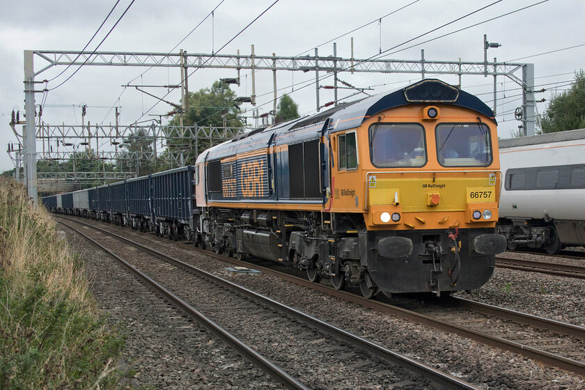 18. 66757, 09.15 Tunstead-Northampton Castle Yard (6B92, 15L) & 390050, VT 12.55 Manchester Piccadilly-London Euston (1A35, 5E), Madeley SJ773439 
 66757 West Somerset Railway leads the 6B52 09.15 Tunstead Colliery to Northampton Castle Yard loaded stone train past Madeley in north Staffordshire. To its left, the 12.55 Manchester to Euston Avanti service passes worked by 390050. 
 Keywords: 66757 09.15 Tunstead-Northampton Castle Yard 6B92 390050 12.55 Manchester Piccadilly-London Euston 1A35 Madeley SJ773439 GBRF Avanti West Coast Pendolino West Somerset Railway