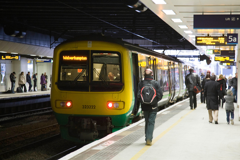 323222, LM 10.31 Walsall-Wolverhampton (2W20), Birmingham New Street station 
 323222 waits in the gloom of Birmingham New Street station to work the cross-Birmingham 2W20 10.31 Walsall to Wolverhampton service. Notice the guard engrossed in his newspaper (or his 'phone?) sitting in the rear cab of the unit. 
 Keywords: 323222 10.31 Walsall-Wolverhampton 2W20 Birmingham New Street station