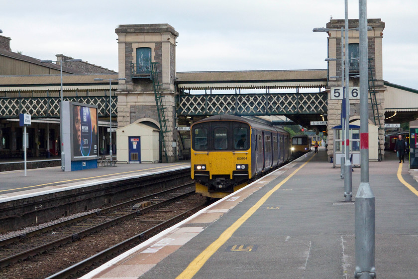 150104, GW 18.52 Paignton-Bristol Temple Meads (2M67, RT), Exeter St. David's station 
 150104 leaves Exeter St. David's station with the 18.52 Paignton to Bristol Temple Meads. Behind it, another Pacer has already arrived from Exeter Central and people can be seen boarding a Paddington bound HST on platform six. 
 Keywords: 150104 2M67 Exeter St. Davids station